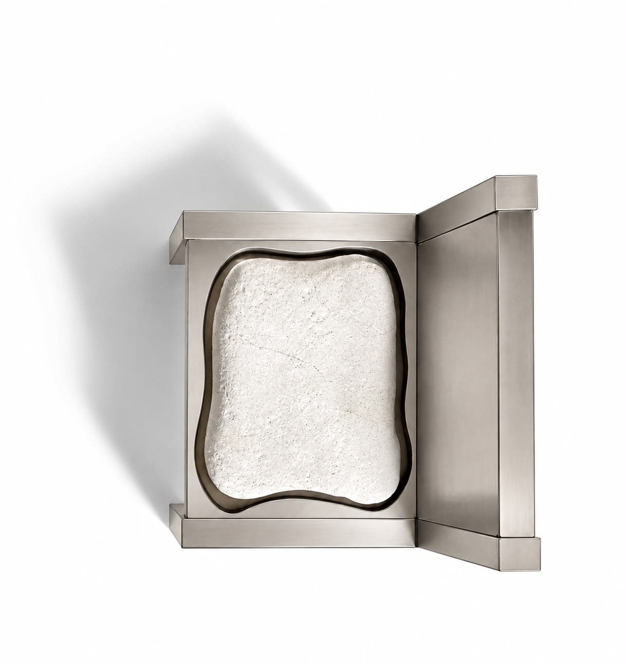 The same chair from above, the stone filling a soft-edged opening cut through the steel seat