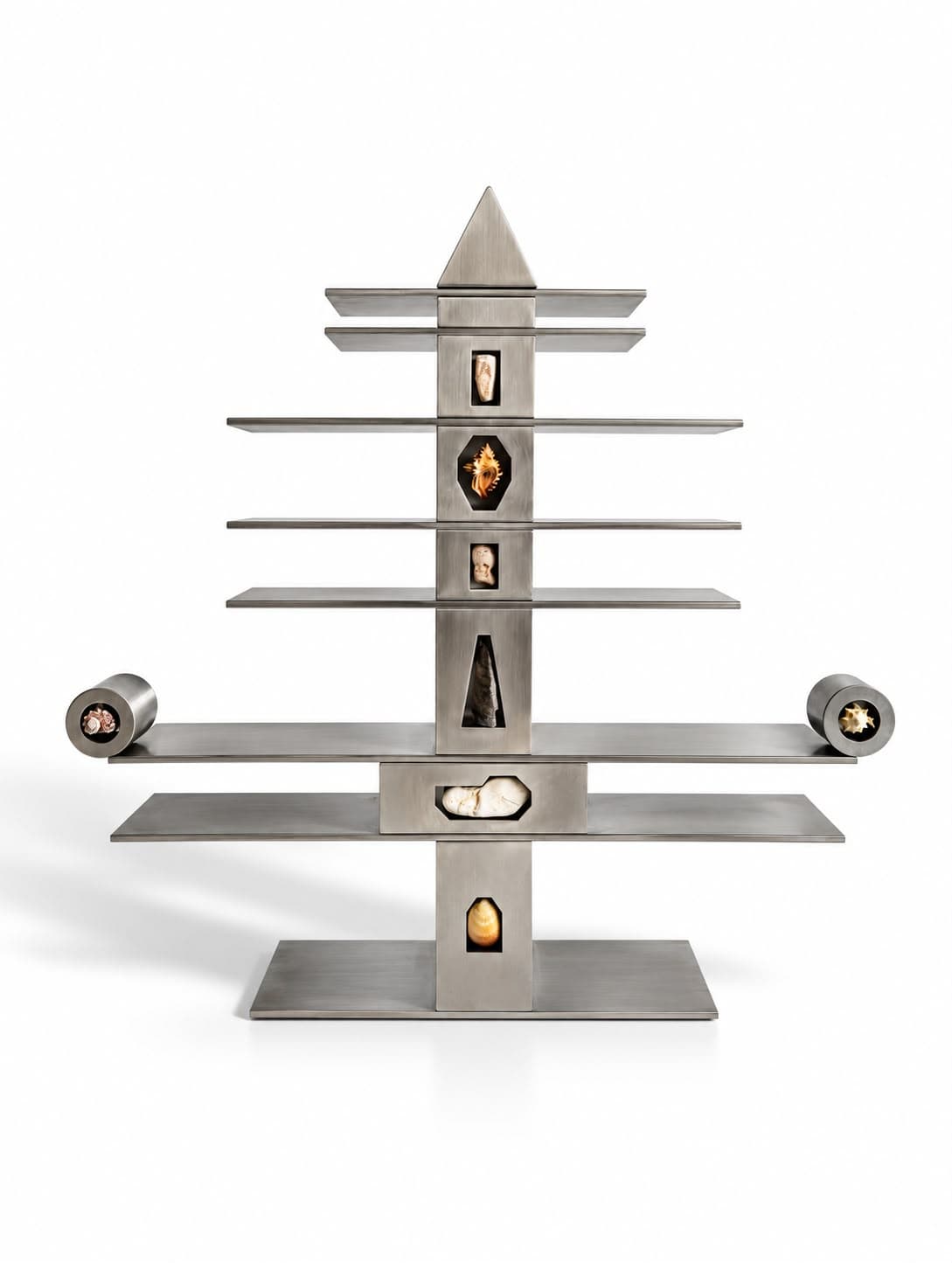 A symmetrical steel tower on a flat plate, its shelves narrowing to a pointed apex, with pieces of rock and shell lit in windows down the central column and a drum cantilevered at each end of the widest shelf
